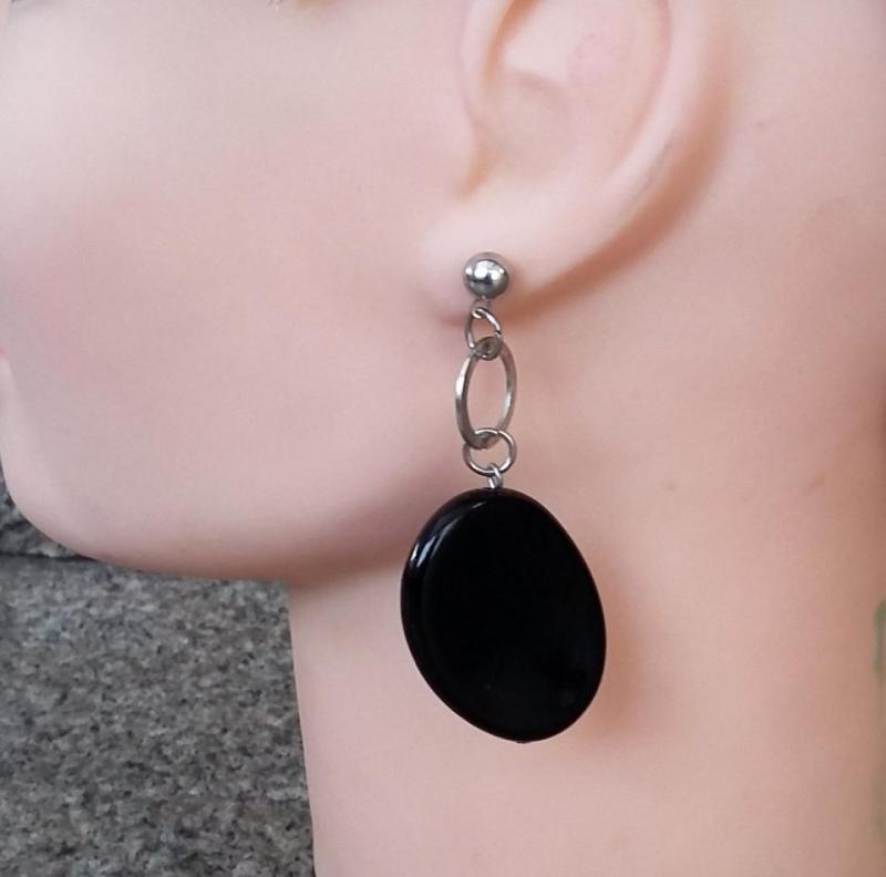 Örhängen med svarta ovala hängen, nickelfri vitmetall, för hål i öronen.